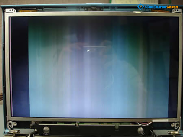 Laptop screen shows vertical lines